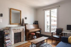 uma sala de estar com um piano e um espelho em Comfortable F4 near Petit-Montrouge em Paris
