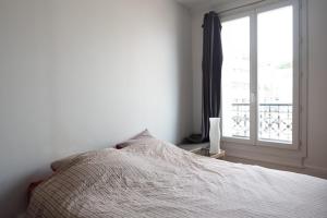 1 dormitorio con cama y ventana en Comfortable F4 near Petit-Montrouge en París