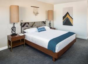 a bedroom with a large bed and a night stand at V Palm Springs in Palm Springs