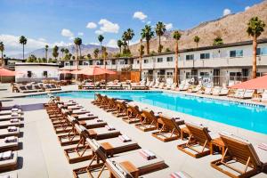una piscina de hotel con tumbonas y un complejo en V Palm Springs en Palm Springs