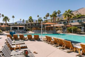 un complejo con piscina, sillas y palmeras en V Palm Springs en Palm Springs