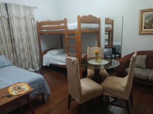 a room with a table and a room with bunk beds at Hospedaje Marita in Lima