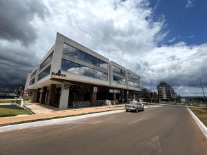 um carro estacionado em frente a um edifício na rua em Noroeste, requinte e bom gosto em Brasília