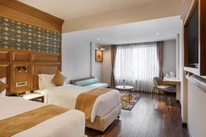 Habitación de hotel con 2 camas y mesa en Hotel Tibet en Katmandú