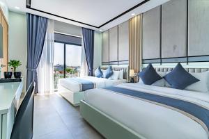 贡布The Square Kampot Hotel的一间有两张床和一扇大窗户的卧室 更多37张照片