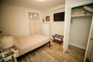 um pequeno quarto com uma cama e uma televisão em Amma's Place em Washington