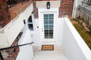 uma porta branca da frente de uma casa de tijolos com escadas em Amma's Place em Washington