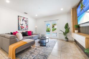 a living room with a couch and a tv at Le Femme Paradise in Miami