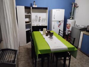 La cuisine est équipée d'une table verte et d'un réfrigérateur. dans l'établissement Depto Arianna, à Los Antiguos