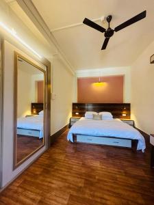 a bedroom with a bed with a mirror and a ceiling fan at Pink Rose Homestay in Gangtok