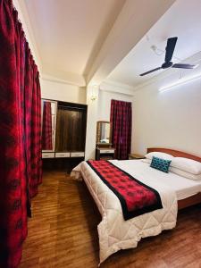 a bedroom with a large bed with red curtains at Pink Rose Homestay in Gangtok