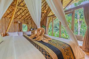 1 dormitorio con 1 cama con techo de madera en Arcada Bali Bamboo House en Sidemen