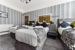 una camera d'albergo con quattro letti e uno specchio di Peaceful and Radiant 3BR Flat a Londra