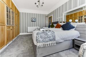 una camera con un grande letto e un lampadario a braccio di Peaceful and Radiant 3BR Flat a Londra