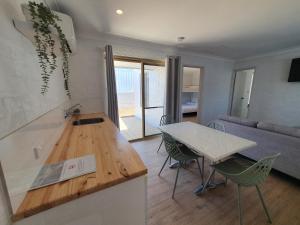 uma cozinha e sala de estar com mesa e cadeiras em The African Reef em Geraldton