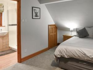 a bedroom with a bed and a sink and a tub at Treetops in Woodchester