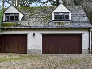 two garage doors in front of a house at Treetops in Woodchester