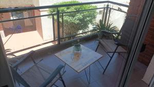 a table and chairs on a balcony with a window at Espacio B in Chivilcoy