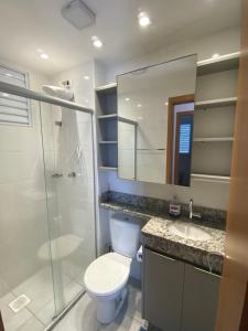 uma casa de banho com um WC, um chuveiro e um lavatório. em Apartamento com Sacada na Gleba, Novo e equipado em Londrina