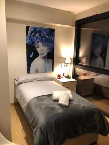 a bedroom with a large bed with a painting on the wall at Llac Blau 1 in El Tarter