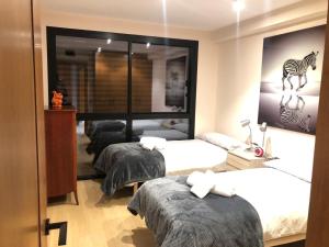 a bedroom with three beds and a picture of a zebra at Llac Blau 1 in El Tarter