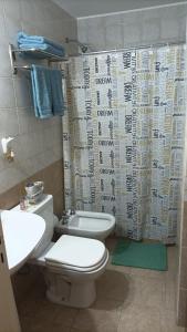 a bathroom with a toilet and a shower curtain at Espacio B in Chivilcoy
