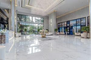a lobby with a large white marble floor and windows at Millennium Tower in Pattaya South