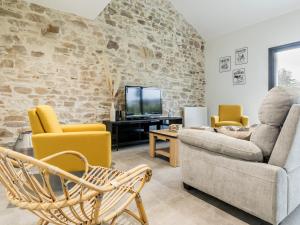 ein Wohnzimmer mit einem Sofa und einem TV in der Unterkunft Gîte Nort-sur-Erdre, 4 pièces, 6 personnes - FR-1-306-1262 in Nort-sur-Erdre
