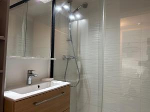 ein weißes Bad mit einer Dusche und einem Waschbecken in der Unterkunft Appartement Seignosse, 2 pièces, 4 personnes - FR-1-239-1008 in Seignosse