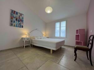 ein Schlafzimmer mit einem Bett, einem Schreibtisch und einem Stuhl in der Unterkunft Villa spacieuse avec piscine privée, WiFi gratuit et jardin clos, à proximité de la mer et du centre-ville - FR-1-246A-279 in Saint-Denis-dʼOléron + 5 Fotos