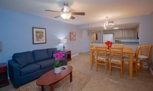 a living room and dining room with a blue couch and a table at Atlantica Resort in Myrtle Beach