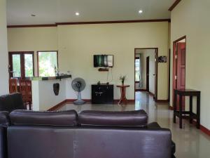 uma sala de estar com um sofá e uma televisão em Links Sunset Beach House em Nathon Bay