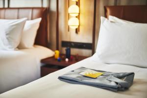 a towel on a bed in a hotel room at voco Osaka Central, an IHG Hotel in Osaka