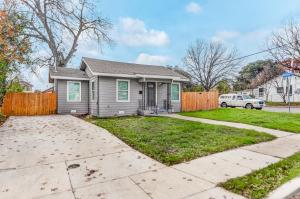 a grey house with a fence and a driveway at Spacious, pet-friendly, 4 bedrooms 2 & half bath home near Riverwalk & Alamo in San Antonio