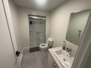 a white bathroom with a toilet and a sink at Cozy Apartment close to Airport in Dieppe