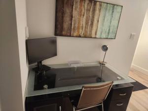 a desk with a computer monitor and a chair at Cozy Apartment close to Airport in Dieppe