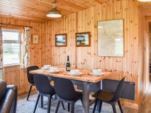 a wooden dining room with a table and chairs at Langston Farm Chalet in Shillingstone