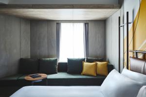 a living room with a couch and a window at voco Osaka Central, an IHG Hotel in Osaka