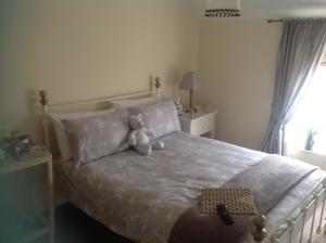 a teddy bear sitting on a bed in a bedroom at Lilly's Pad in Keelby