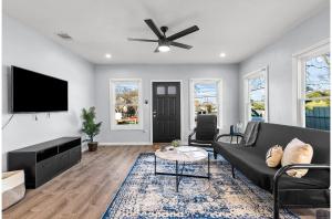 Una sala de estar con un sofá negro y un televisor de pantalla plana. en Inviting 4BR2.5BA Downtown Home with Ample Space, en San Antonio