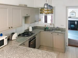 a kitchen with white cabinets and a stove top oven at Hammer Bank Lodge in Windermere