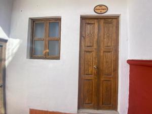 dom z drewnianymi drzwiami i oknem w obiekcie Hotel Noche Azul w mieście Real de Catorce