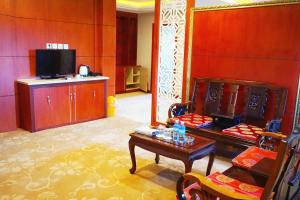 a living room with a table and a tv at Dansavanh Vientiane Hotel in Vientiane