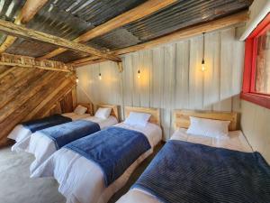 Un grupo de 4 camas en una habitación en Hermosa y Nueva Cabaña de campo - La Candelaria Farm House, en Cuenca