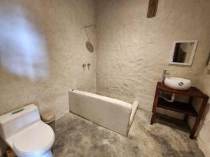 y baño con aseo blanco y lavamanos. en Hermosa y Nueva Cabaña de campo - La Candelaria Farm House, en Cuenca
