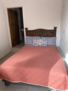 een slaapkamer met een groot bed en een oranje deken bij Hotel Noche Azul in Real de Catorce
