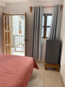 a bedroom with a bed and a television in front of a door at Hotel Noche Azul in Real de Catorce