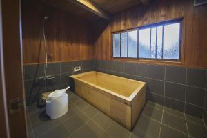 a bathroom with a wooden tub and a window at NIPPONIA 福住 宿場町 in Fukuzumi