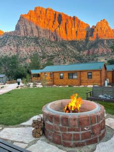 eine Feuerstelle mit einem Berg im Hintergrund in der Unterkunft Zion Canyon Cabins in Springdale