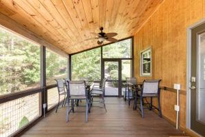 eine abgeschirmte Veranda mit Stühlen und einem Deckenventilator in der Unterkunft Ridgetop views near Asheville w/Private Hot Tub in Burnsville